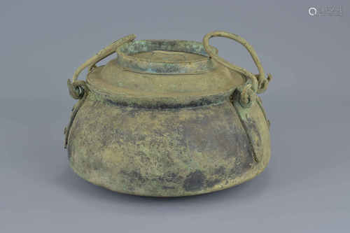 A Chinese Han dynasty or later bronze cooking pot with cover and two handles.16cm height