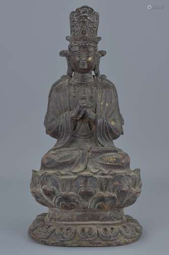 A Chinese bronze figure of seated Guanyin on lotus stand with traces of gold gilding. 30Cm tall