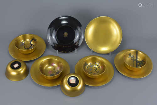 A collection of six Japanese vintage lacquer gold bowls painted with trees and flowers together with