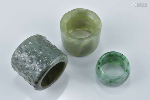 Two Chinese jade archers rings together with a single pale and dark green jadeite ring. Slight chip