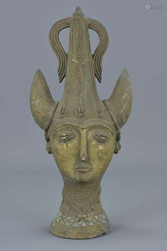 A Persian bronze sculpture of head with horned helmet. 28Cm tall