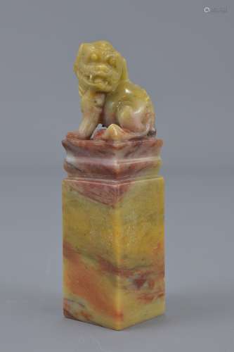 A Chinese 20th century soapstone seal carved with a seated lion on stand. Three character seal mark