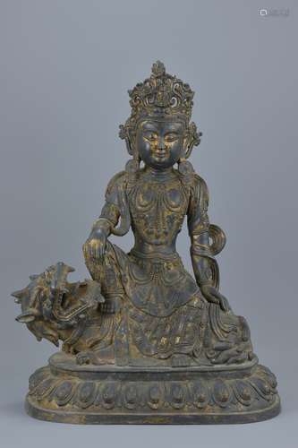 A Chinese 18th century Chinese bronze Guanyin seated on a mythical beast with traces of gold gilding