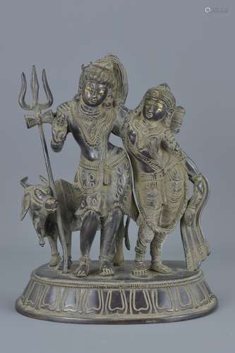 An Eastern bronze sculpture of two figures and cow. 30Cm tall