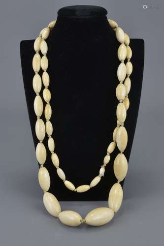 A long vintage graduated ivory beaded necklace. Total 50 beads. Largest bead approx. 4cm length.