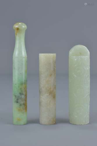 Three Chinese jade items including one cigarette holder, a jade hat piece and one long bead with ins