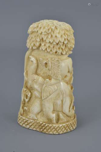 An African bone carving depicting lions chasing an elephant. 9.5cm tall