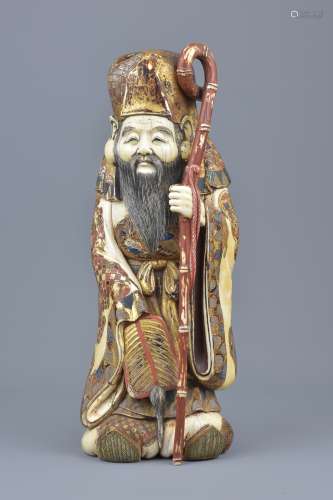 A Japanese Meiji period 19th century carved and painted ivory figure of Shulu holding a staff. Maker