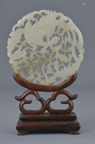 A 19th century Chinese carved white jade plaque with pierced decoration depicting a phoenix and flow