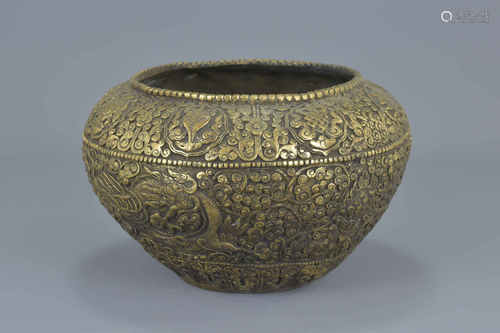 A Tibetan 19th century bronze bowl heavily decorated with dragons and eight Buddhist symbols. 14Cm x