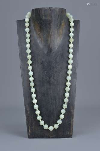 A Chinese pale celadon jade beaded necklace. Total 51 beads with silver clasp stamped 'silver'. Bead