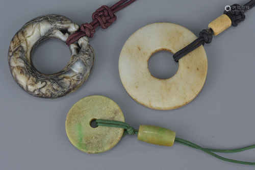 Three Chinese jade bi discs, one carved and two without decoration. 6Cm diameter, 5.5cm diameter and