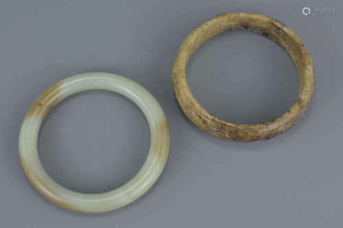 Two Chinese jade bangles. One carved with three dragons. Approx. 8Cm diameters (2)