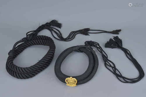 Islamic braided rope belt and headband fitted with metal badge of arms with inscription.