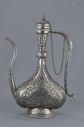 A large Persian repousse sliver alloy metal ewer with cover attached to chain. 44Cm tall