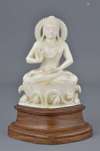 A carved ivory figure of a seated Hindu God attached to wooden stand. 18Cm tall with stand