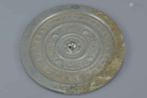 A Chinese Han dynasty or later circular bronze mirror with inscriptions and animal pattern with some