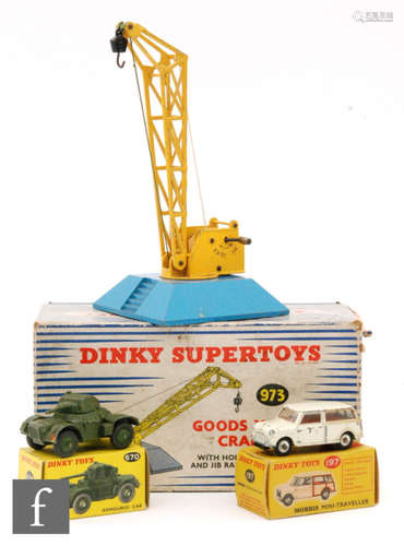 A Dinky Toys #197 Morris Mini Traveller diecast model with cream body, red interior and black gloss base in red and yellow picture box, with two other boxed Dinky Toys, a #670 Armoured Car and a #973 Goods Yard Crane with blue base. (3)