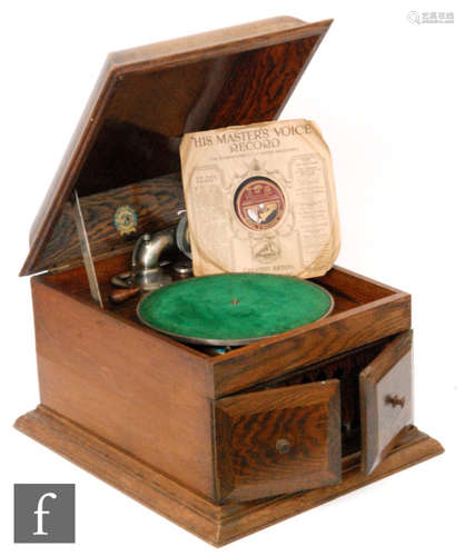 A 1920s oak cased table top gramophone retailed by Meads Balsall Heath Birmingham with needle tins and handle.