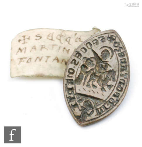 A Medieval bronze Vessica seal matrice for MARRTINI D FONTANESO depicting Christ or a saint on horseback above a praying figure, old identification tag, 37mm.