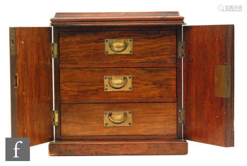 A small Victorian figured walnut three drawer cabinet enclosed by a pair of arch panelled doors, width 27cm.