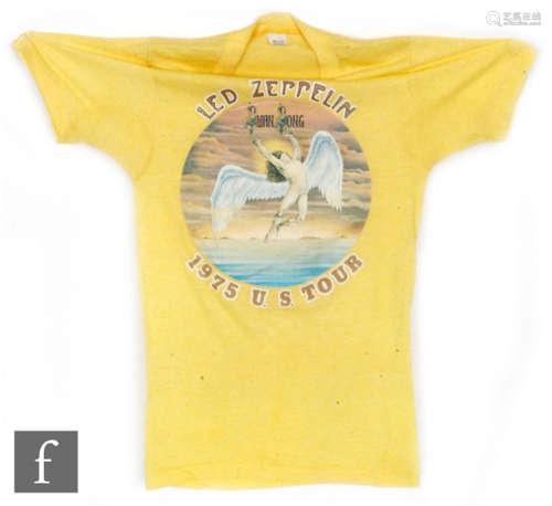 A Led Zeppelin original 'Swan Song' 1975 U.S Tour t-shirt, the yellow t-shirt with printed text, small (34-36). PROVENANCE: Given to the current owner by the manager of the Swan Song tour.