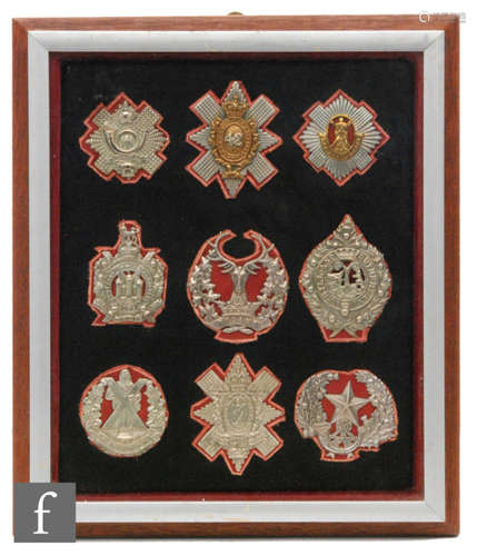 A group of nine military badges to include The Royal Scots, Cameroon Highlanders, Black Watch, etc, 35cm x 30cm, framed