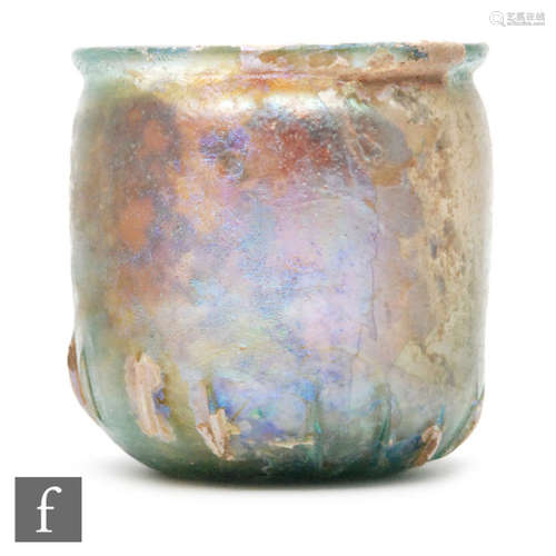 Roman 2nd to 3rd Century AD - An iridescent green glass beaker with flared rim and slashed ribs to the base, height 7cm  Provenance - Sotheby & Co, lot 3 Monday 1st December 1969