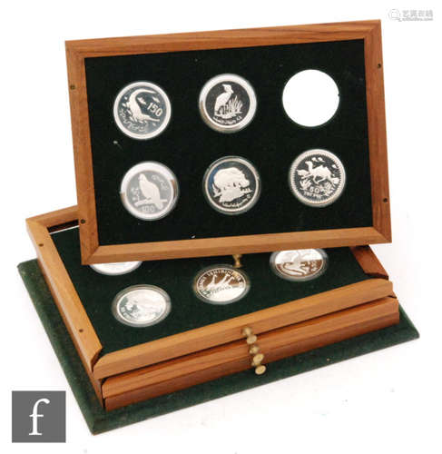 Royal Mint - A set of twenty four silver proof coins for the World Wild Life Fund contained in four fitted teak trays, (no cabinet)