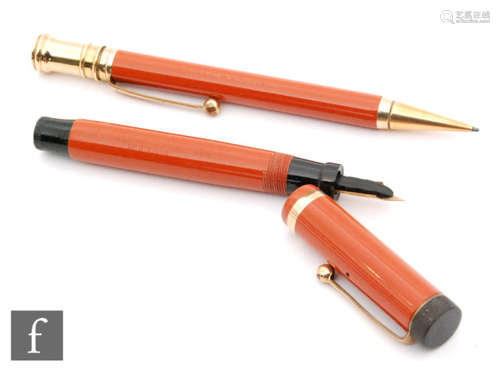 A Parker Duofold Junior fountain pen, orange with 14ct gold N nib and a matching propelling pencil. (2)