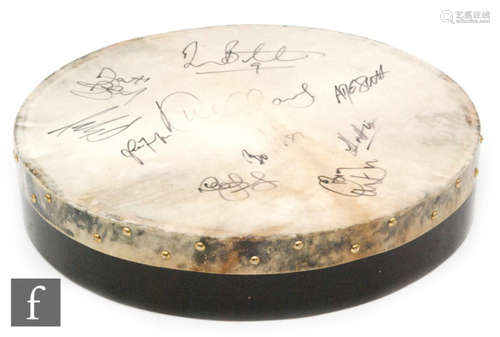 A skin covered drum signed in black felt pen by members of the Irish folk band the Dubliners, with beater.