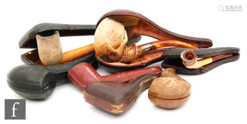 A collection of late 19th to early 20th Century cased Meerschaum pipes, including an example formed with a hand holding the bowl, another formed as a horse hoof and two of plain form, together with three empty cases. (7)