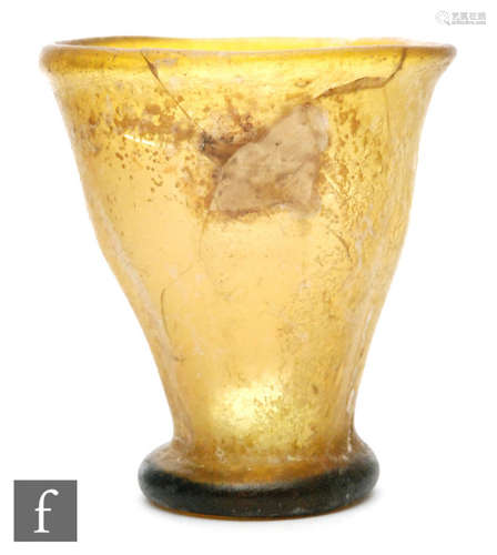 Roman 2nd to 4th Century AD - A small amber glass beaker of tapering form on a circular foot, height 7.5cm, A/F