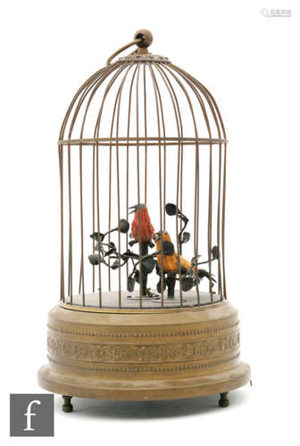 A post 1950s Griesbaum singing bird-in-a-cage, the singing birds with movement to their beaks and tails, the cage on a beaded decorated base, height 30cm