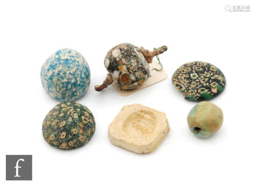 Roman 2nd to 4th Century AD - Three millefiori glass gaming counters, a lozenge shaped cream coloured gaming counter with detail to centre, a mosaic bead with double iron loop swivel and a turquoise bead (6)