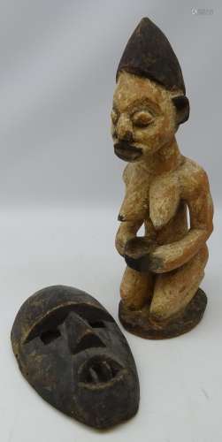 Nigerian Yoruba carved figure of a kneeling woman holding a bowl with traces of white pigment,
