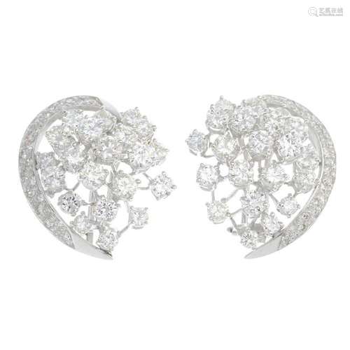 A pair of diamond earrings. Each designed as scattered