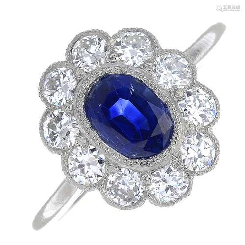 A sapphire and diamond cluster ring. The oval-shape