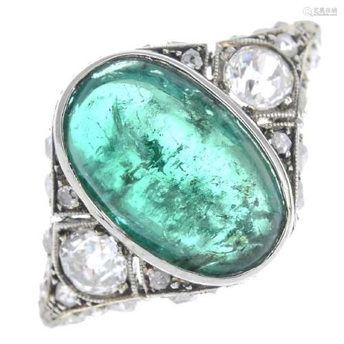 An emerald and diamond ring. The oval emerald cabochon,