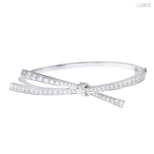 An 18ct gold diamond bangle. The brilliant-cut diamond