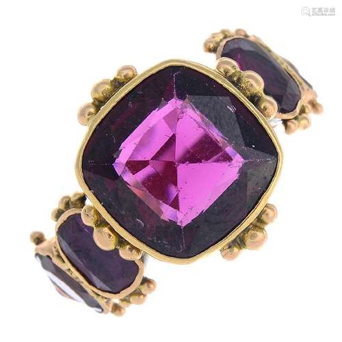 A garnet and ruby ring. The cushion-shape garnet, to