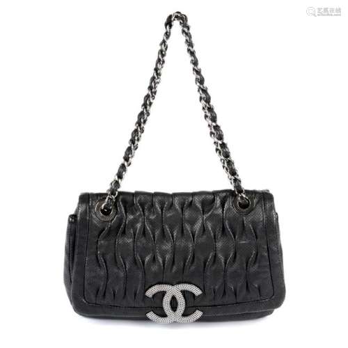 CHANEL - a black perforated leather single flap