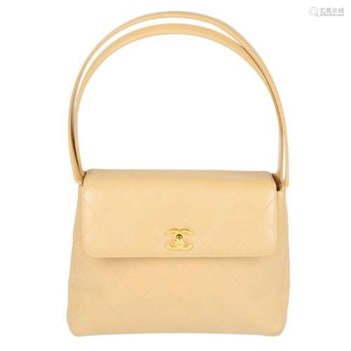 CHANEL - a beige leather handbag. Designed with a