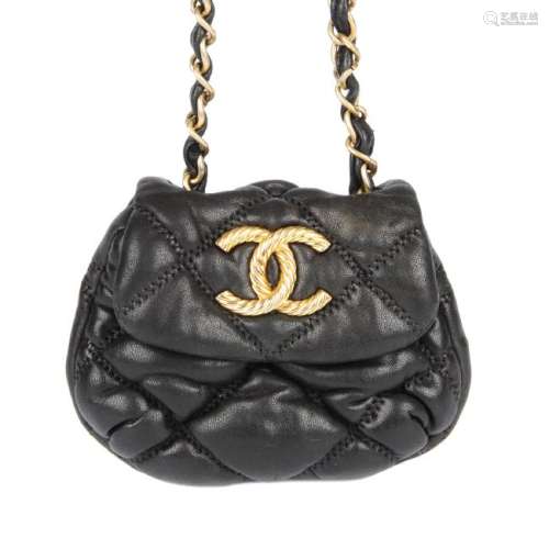 CHANEL - a mini quilted purse. Crafted from soft black