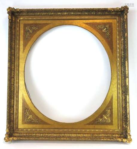 A 20th century oval mirror frame with a rectangular gilt border,