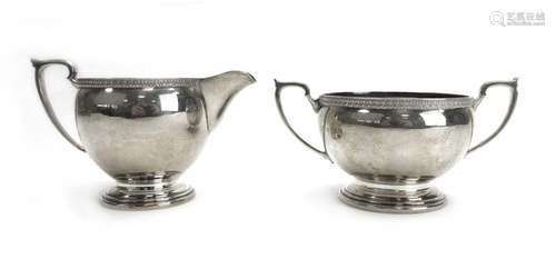 A silver two handled sugar bowl in the Neo-Classical manner and a matching milk jug,