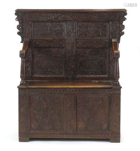 An 18th century-type carved oak and panelled monk's bench,