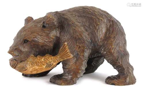 A 'Black Forest' carved beech figure modelled as a bear clutching a fish, h.