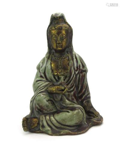 A Chinese glazed and gilt decorated stoneware figure modelled as figure at rest, h.