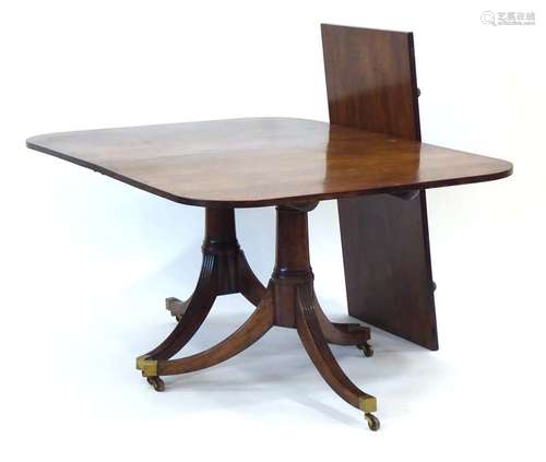 A 19th century mahogany twin-pedestal dining table, with one fitted leaf,